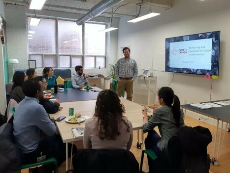 Merlin Chatwin (standing, center) leads a workshop on monitoring and evaluation for members of Civic Hall Toronto on February 27, 2020.