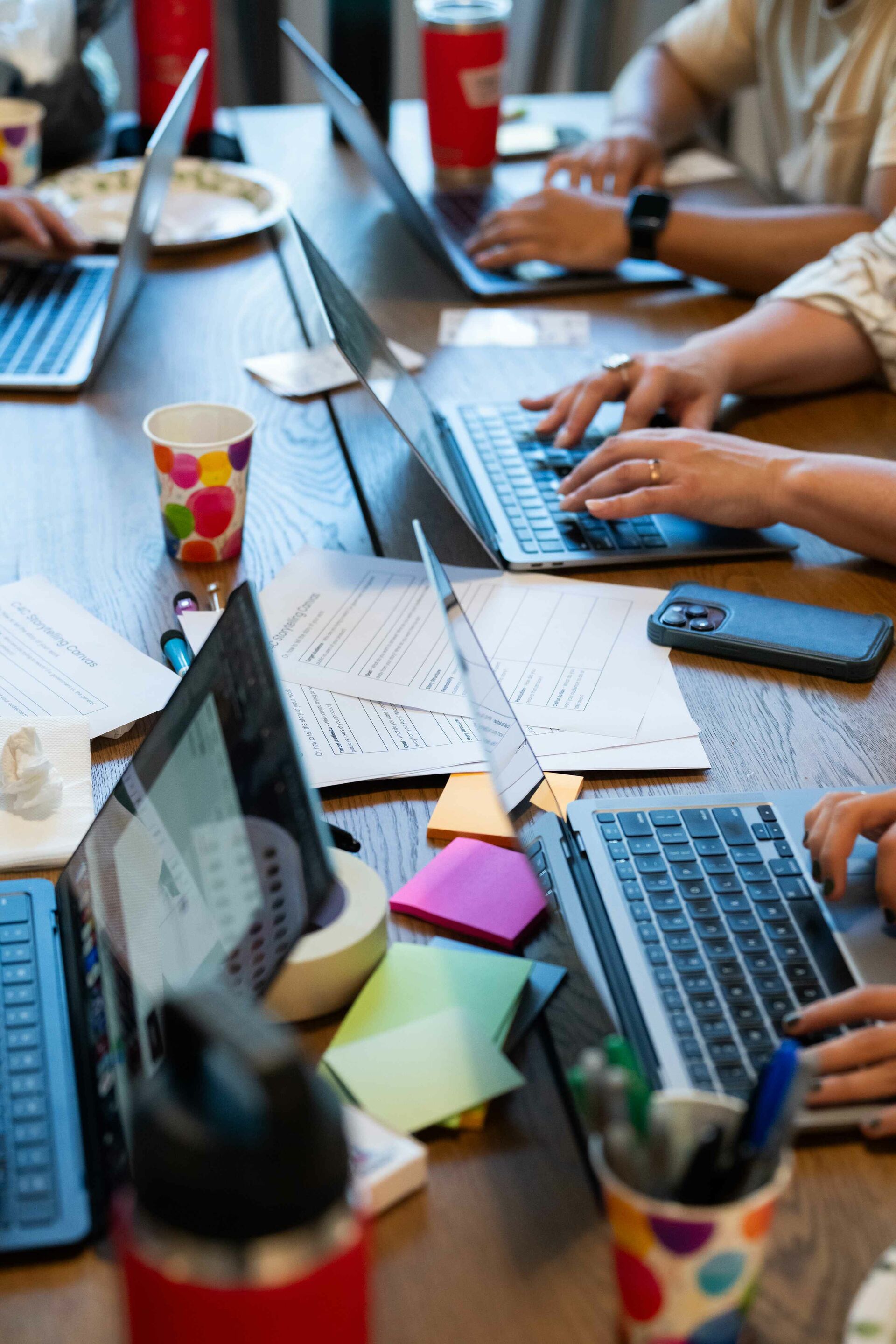 A shot of four people working on laptops showing only their hands