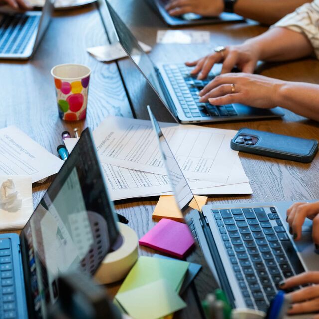 A shot of four people working on laptops showing only their hands