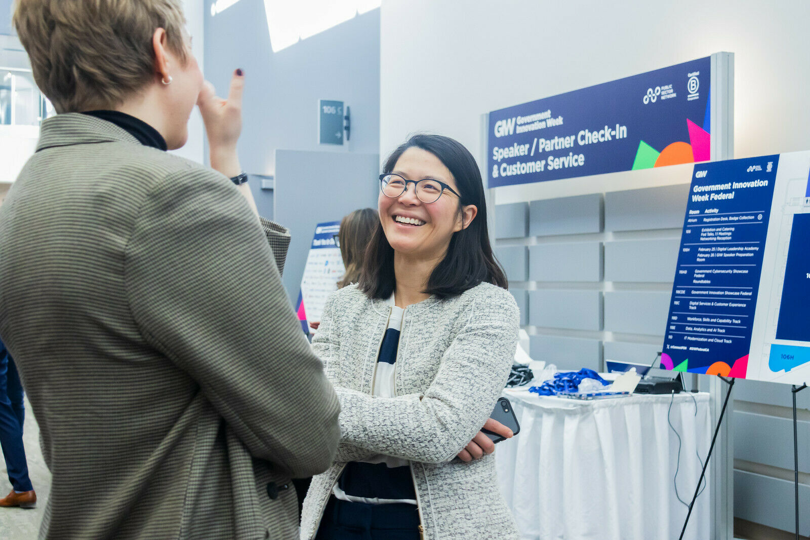Dorothy Eng smiling while talking to a person at Public Sector Network's Federal Government Innovation Week in Ottawa February 2025