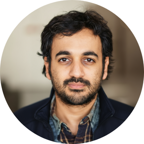 A man with brown hair a beard and a plaid shirt